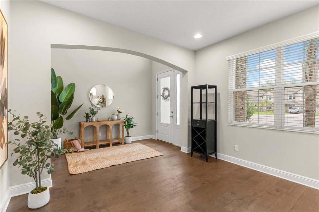 An entryway with hardwood floors, an arched opening, a console table, and a large window — 19361 EAGLE CREEK LANE, TAMPA, FL