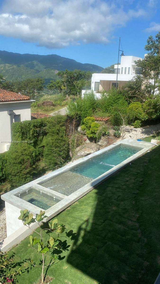 An elevated rectangular swimming pool sits in a grassy yard with mountain views — 46 Cerro Real Alto Las Palomas, CR, CR