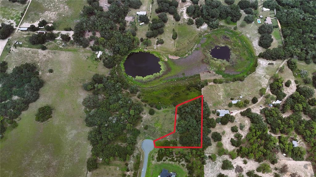 An aerial view shows a vacant, wooded residential lot outlined in red at a cul-de-sac — 000 DARLINGTON AVENUE, LADY LAKE, FL