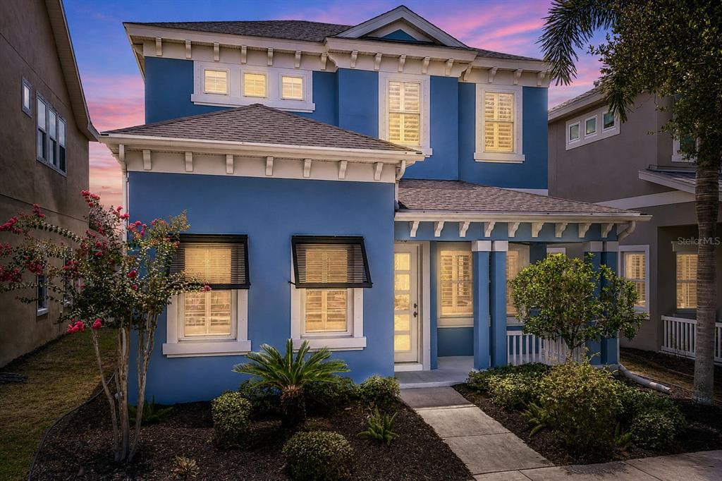 A two-story blue house with a front porch, white trim, and a landscaped front yard — 510 WINTERSIDE DRIVE, APOLLO BEACH, FL