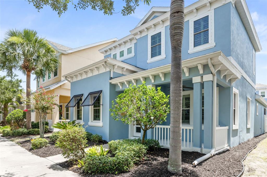 A two-story blue house with a front porch and a palm tree in the yard — 510 WINTERSIDE DRIVE, APOLLO BEACH, FL
