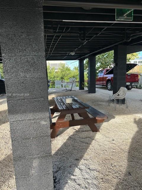 A wooden picnic table sits on a gravel patio under an elevated building structure — 74 Pelican Ln, Big Pine FL 33043, BIG PINE, FL