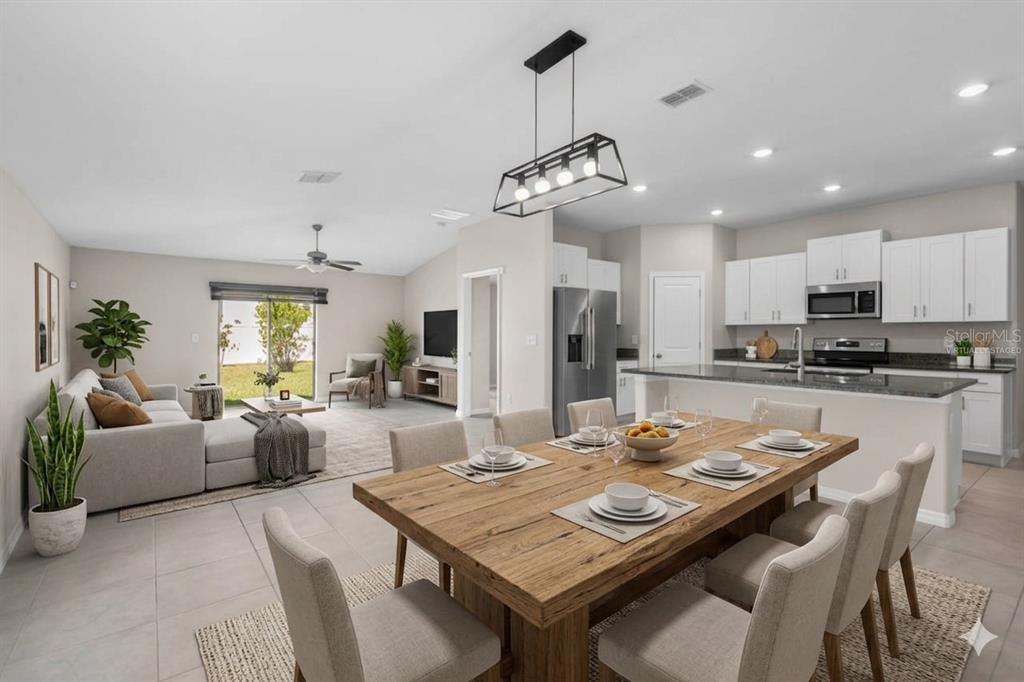 An open-concept living and dining area features a wooden table, kitchen island, and tiled floors — 6823 KING CREEK DRIVE, SUN CITY CENTER, FL