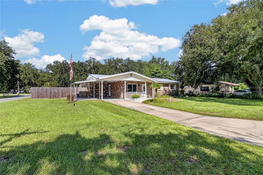 A single-story brick house with a metal roof, carport, and a large front lawn — 2801 BLAIN ACRES ROAD, PLANT CITY, FL