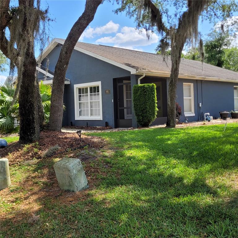 A single-story blue house with a screened front porch sits behind trees and grass — 991 OLD CUTLER ROAD, LAKE WALES, FL