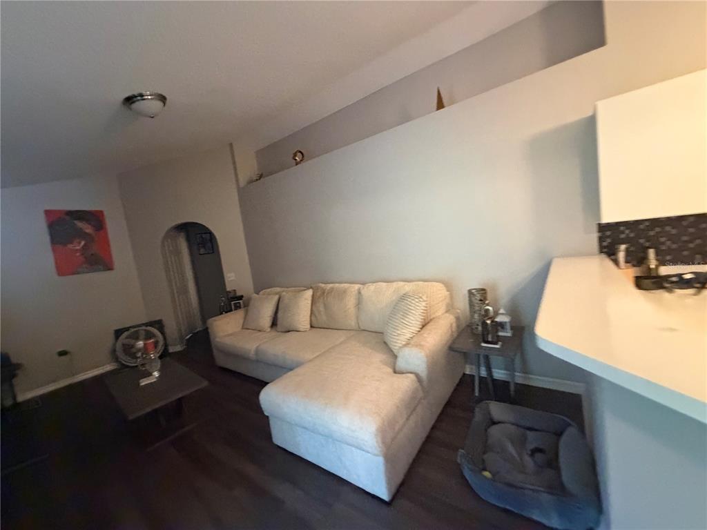 A living room features a sectional sofa, a coffee table, and an arched doorway — 346 COCOA COURT, KISSIMMEE, FL