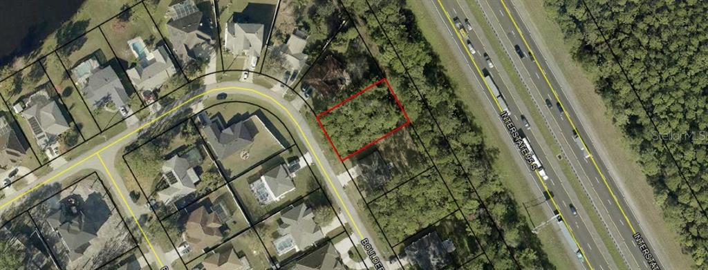 This aerial map shows a vacant residential lot outlined in red next to a highway — 191 BOULDER ROCK DRIVE, PALM COAST, FL