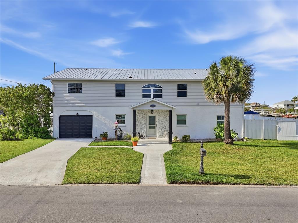 A two-story house with a metal roof, white siding, and a single-car garage — 3173 GULFVIEW DRIVE, HERNANDO BEACH, FL