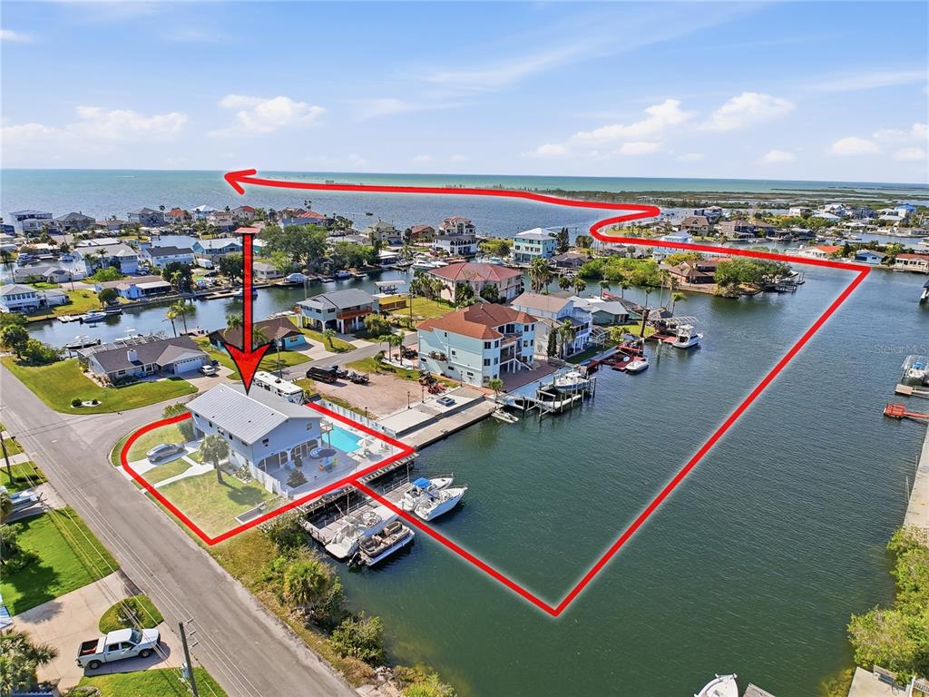 An aerial view shows a waterfront house with a pool and boat dock on a canal — 3173 GULFVIEW DRIVE, HERNANDO BEACH, FL