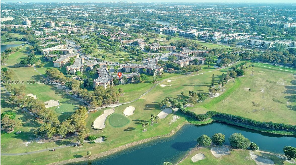 An aerial view shows a multi-story residential complex situated on a golf course with water — 6301 N Falls Cir Dr # 313, Lauderhill FL 33319, LAUDERHILL, FL