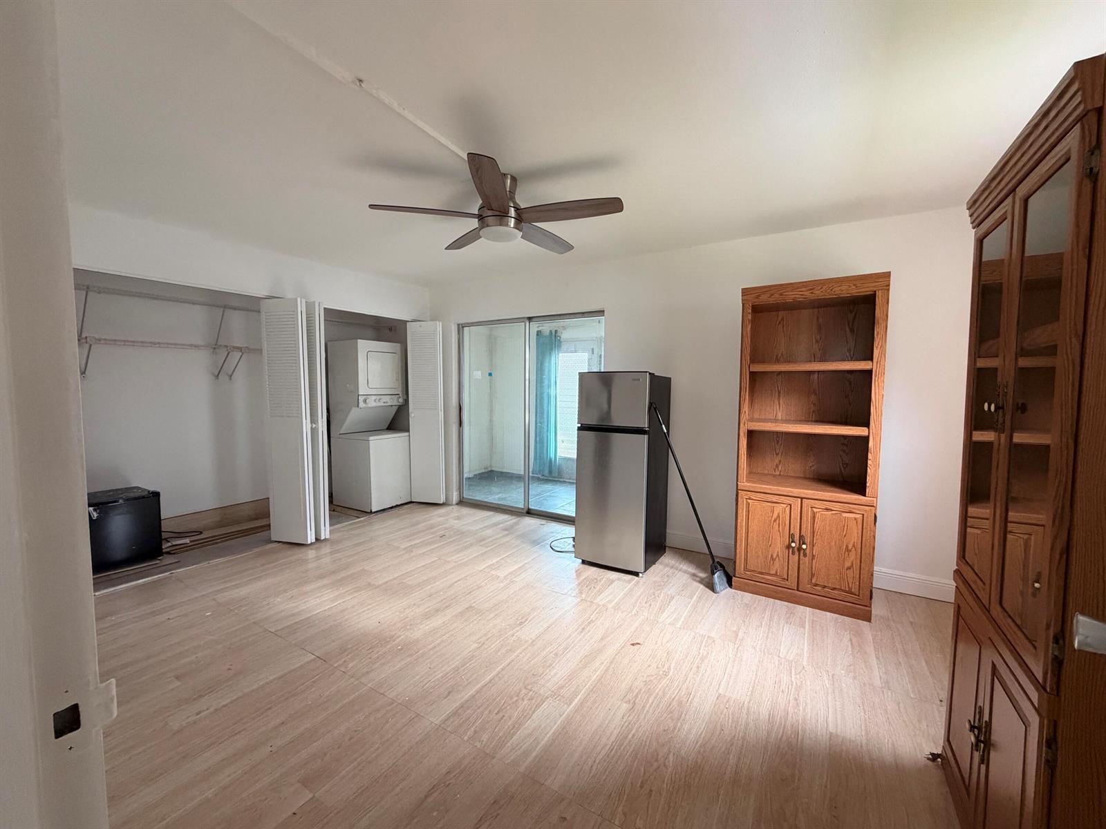 A room with light wood-look flooring, a ceiling fan, a refrigerator, and a laundry closet — 355 Brittany H, Delray Beach FL 33446, DELRAY BEACH, FL
