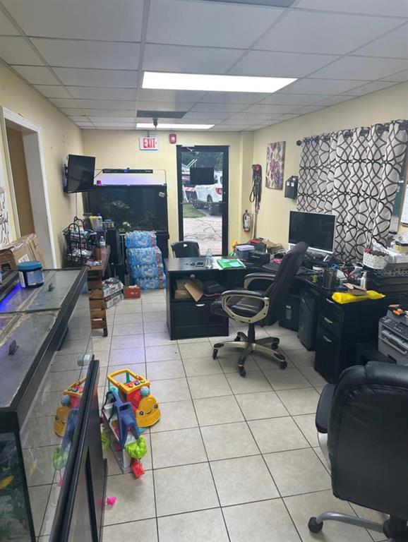 An office space features tile flooring, a desk with a chair, and two large fish tanks — 2920 W AIRPORT BOULEVARD UNIT 150, SANFORD, FL