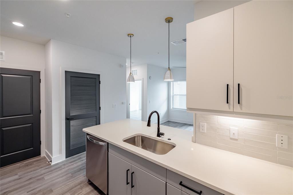 A kitchen features white cabinets, a stainless steel sink, and dark gray doors — 1420 LAKEFRONT DRIVE UNIT 4305, SARASOTA, FL