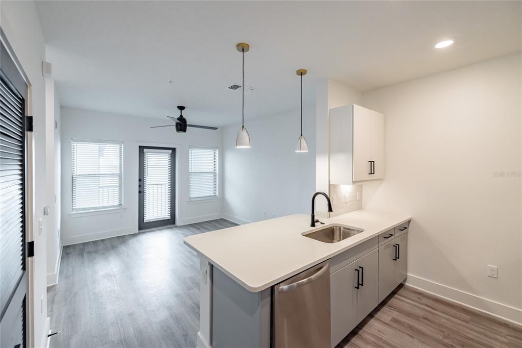 A kitchen with light gray cabinets and white countertops overlooks an open living area — 1420 LAKEFRONT DRIVE UNIT 4305, SARASOTA, FL