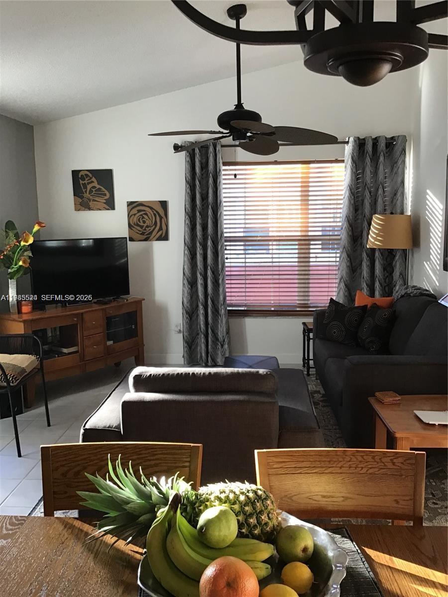 A living room features a television, sofa, and dining table with a bowl of fruit — 609 Waterside Dr # 609, Hypoluxo FL 33462, HYPOLUXO, FL