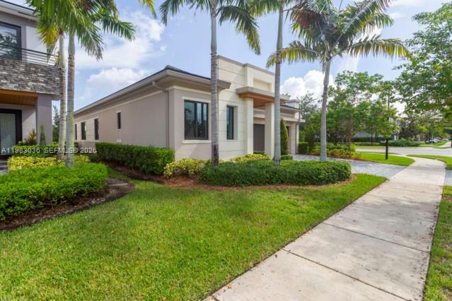 A single-story house with a beige exterior, palm trees, and a sidewalk in the foreground — 10705 Pacifica Way, Parkland FL 33076, PARKLAND, FL