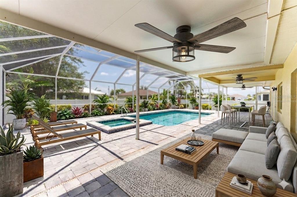 A covered patio features a swimming pool, hot tub, lounge chairs, and outdoor seating — 3310 SW 26TH AVENUE, CAPE CORAL, FL