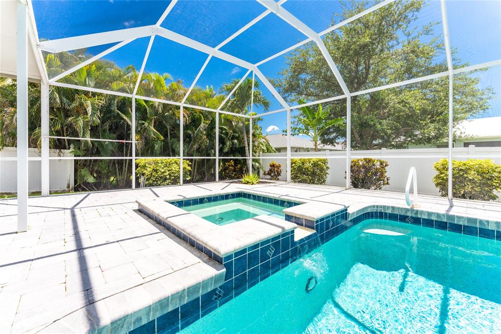 A screened-in patio features a swimming pool with an integrated raised spa and tile finish — 3310 SW 26TH AVENUE, CAPE CORAL, FL
