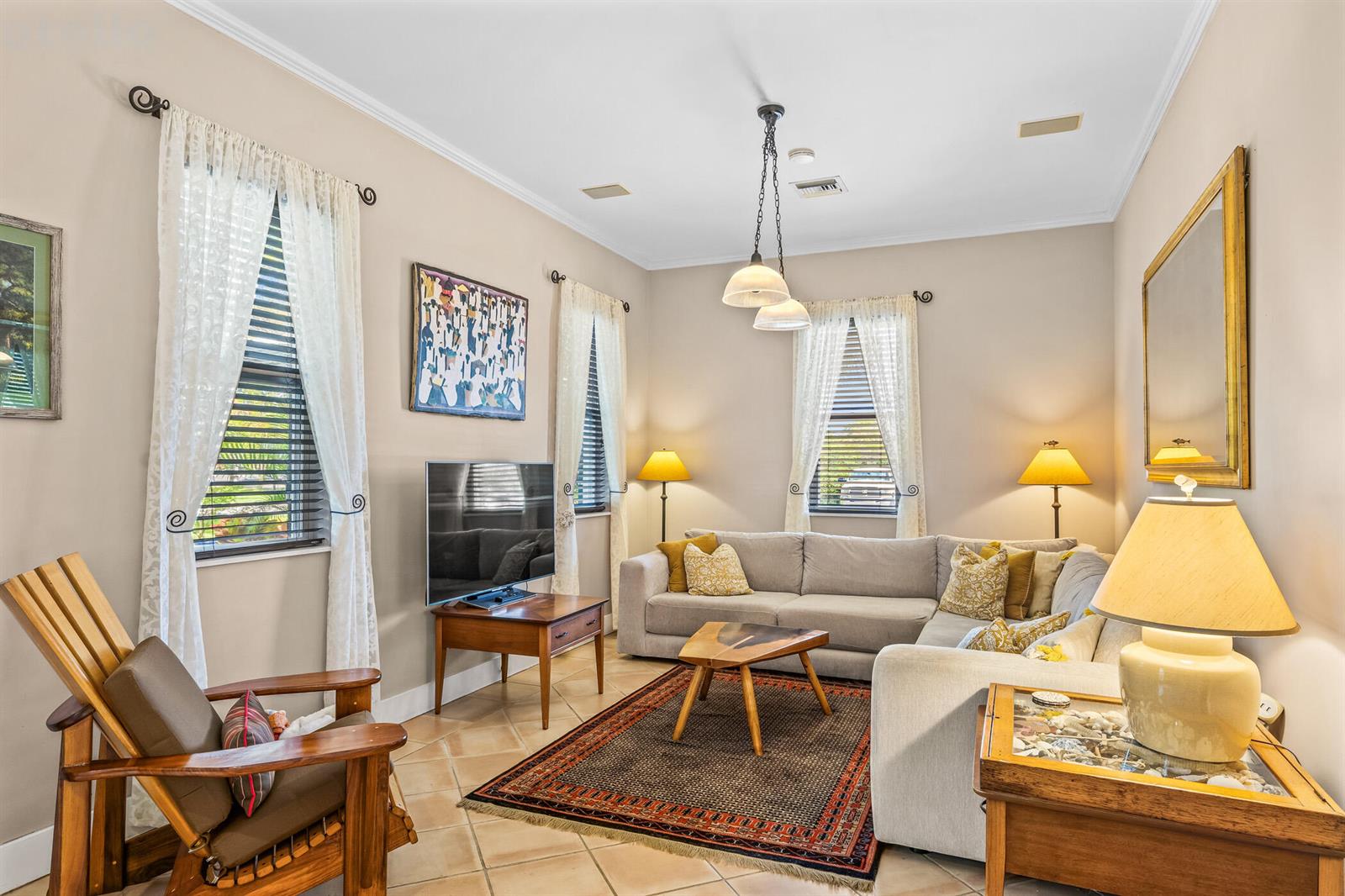 A living room features a sectional sofa, a wooden rocking chair, and a patterned rug — 3628 Rio Vista Boulevard, Vero Beach FL 32963, VERO BEACH, FL