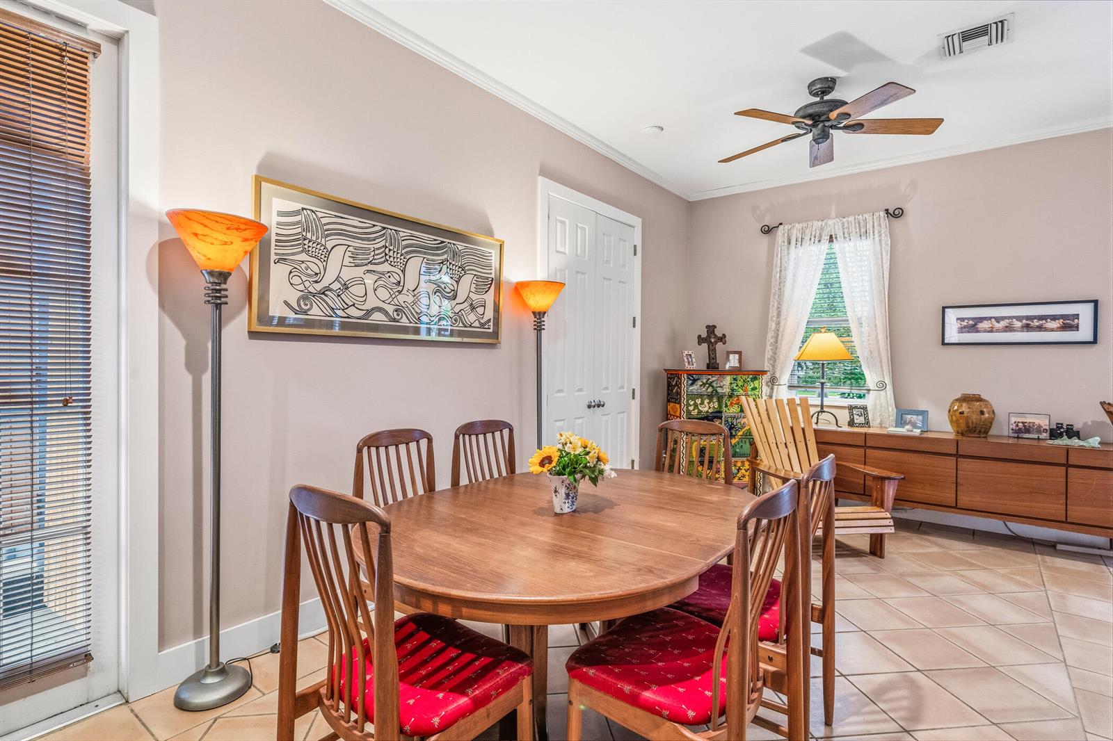 A dining room features a wooden table, six chairs with red cushions, and tile flooring — 3628 Rio Vista Boulevard, Vero Beach FL 32963, VERO BEACH, FL