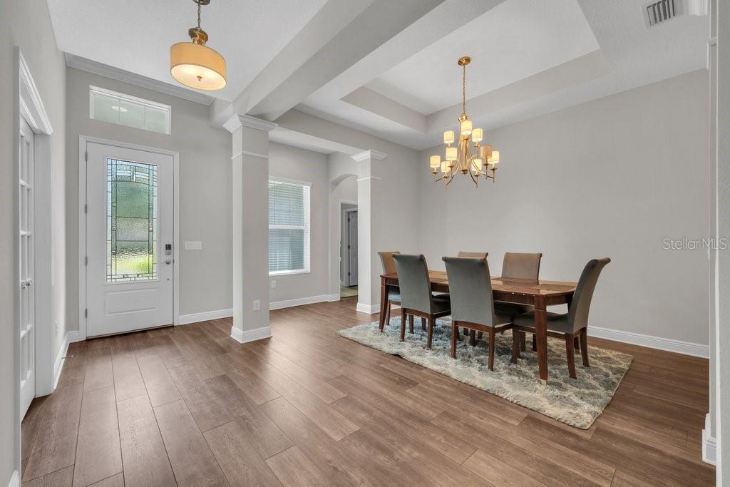 A dining room with wood-look flooring, a chandelier, and a table with six chairs — 1210 LOREA LANE, BRANDON, FL