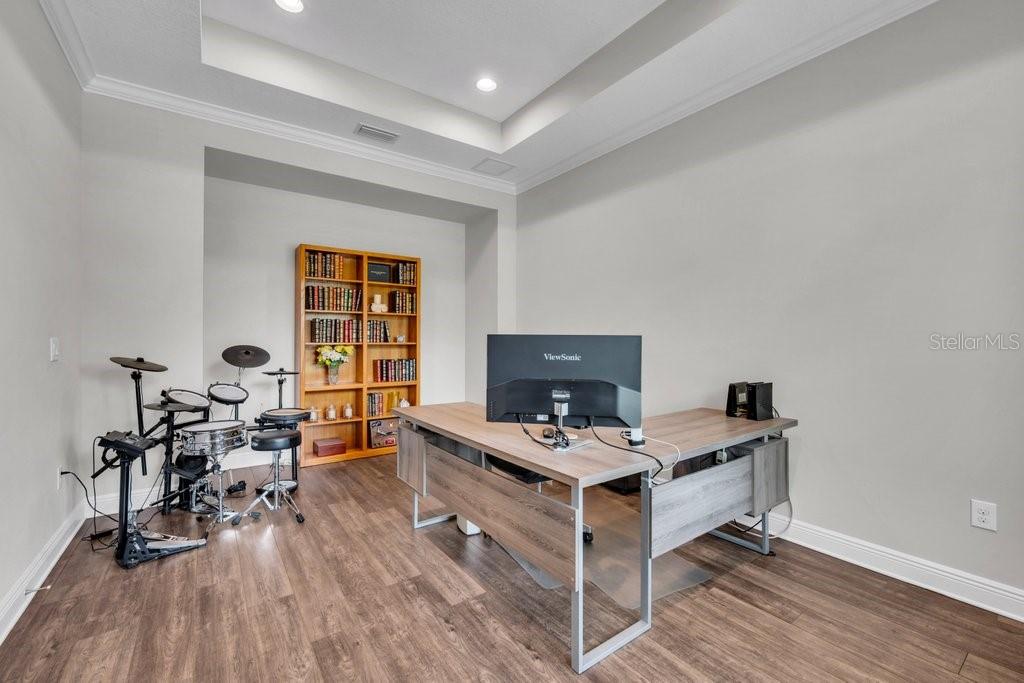 A home office features a wooden desk, a computer monitor, a bookshelf, and a drum set — 1210 LOREA LANE, BRANDON, FL