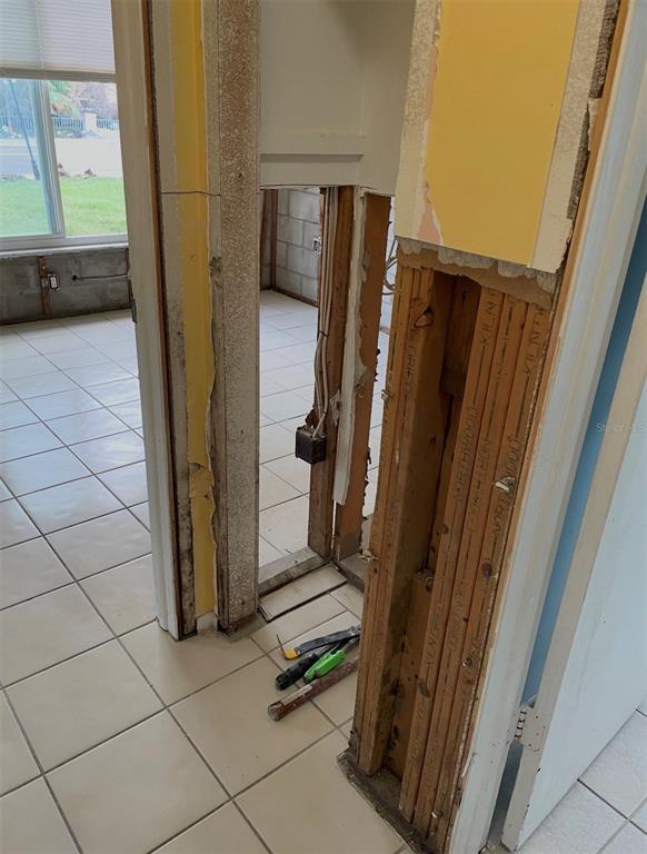 A view through a doorway showing exposed wall studs and damaged drywall in a room — 16101 GULF BOULEVARD, REDINGTON BEACH, FL