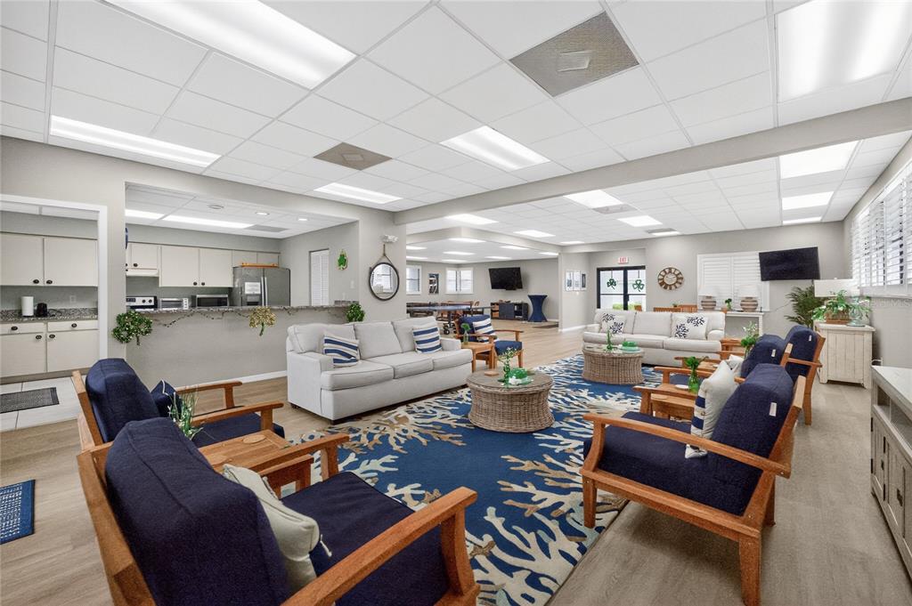 A spacious community room features a kitchen, multiple seating areas, and a large blue rug — 2601 W MARION AVENUE UNIT 42A, PUNTA GORDA, FL