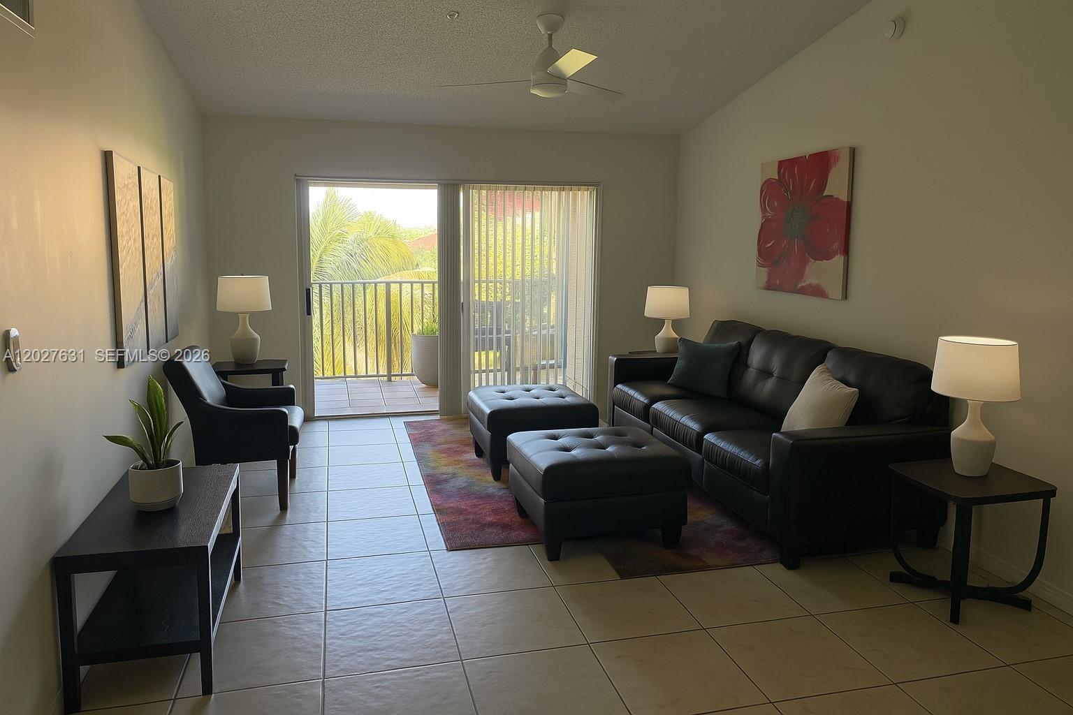 A living room features tile floors, a dark leather sofa, two ottomans, and a balcony — 2081 Renaissance Blvd # 306, Miramar FL 33025, MIRAMAR, FL