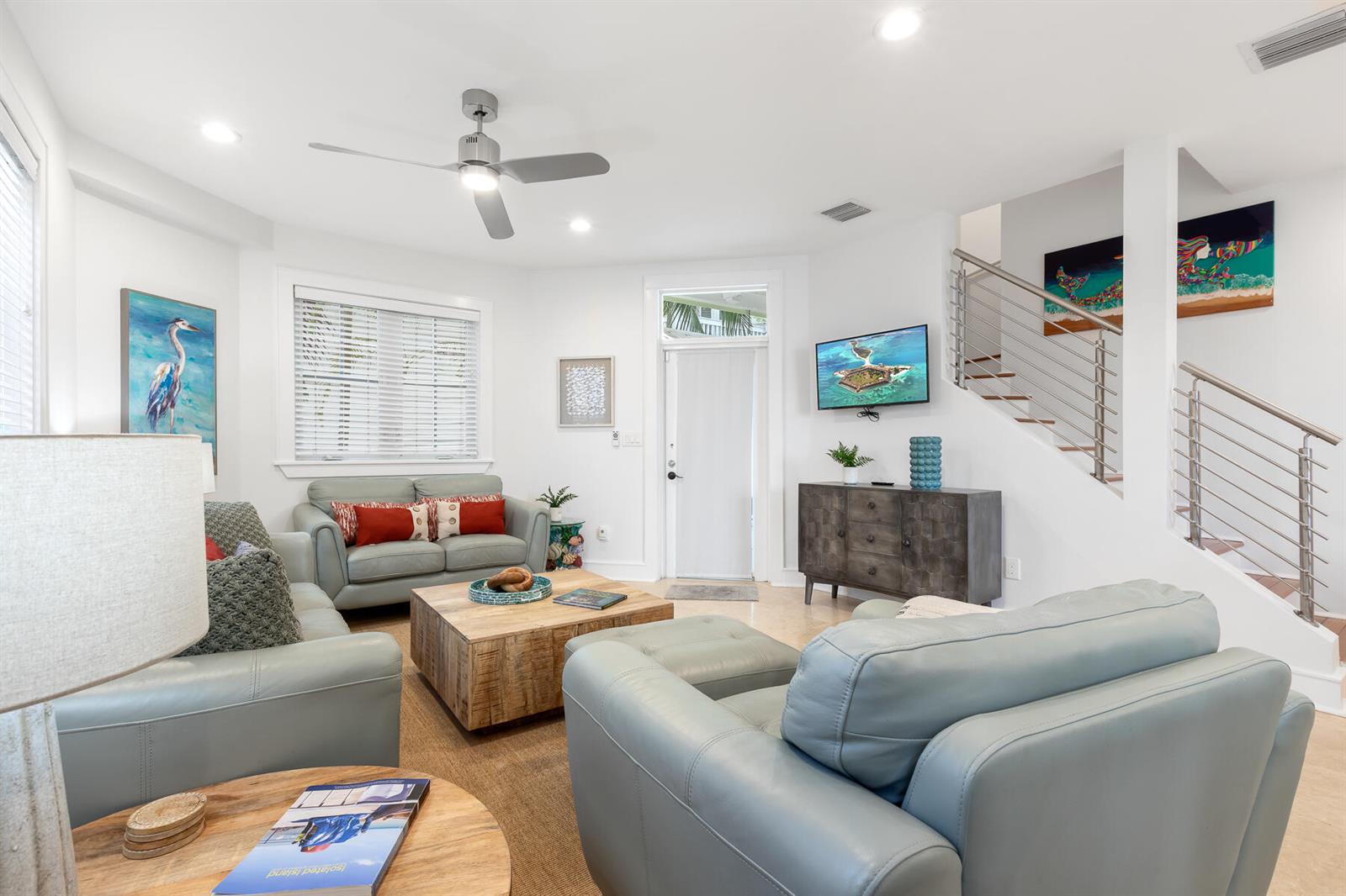 A living room features light blue leather furniture, a wooden coffee table, and a staircase — 1011 Simonton Street # 1, Key West FL 33040, KEY WEST, FL