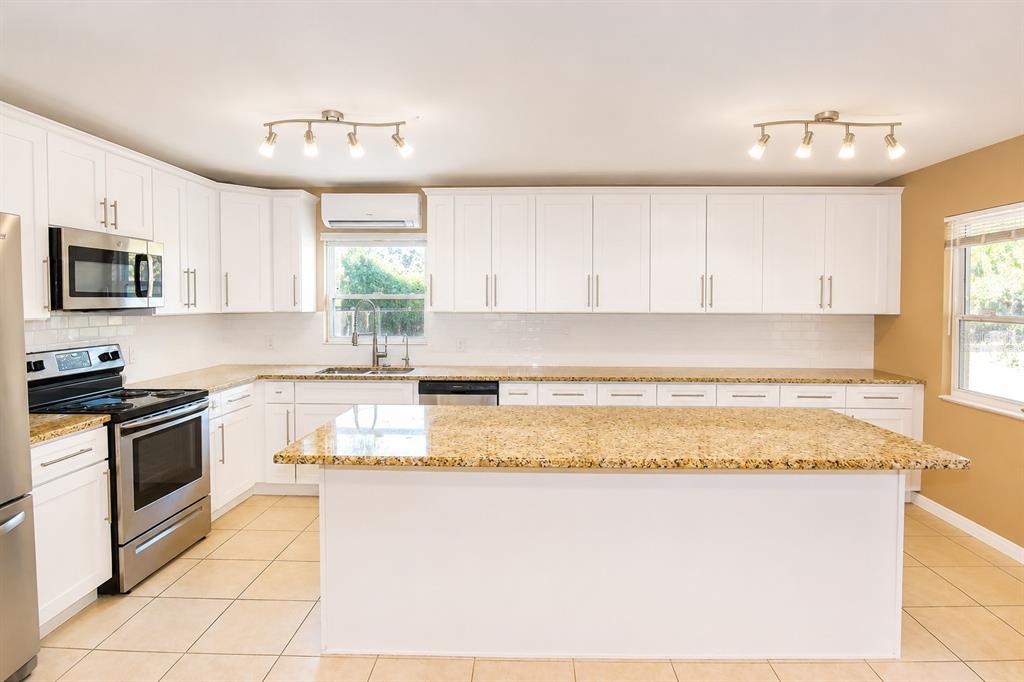 A kitchen with white cabinets, granite countertops, stainless steel appliances, and tile flooring — 6848 COPPERFIELD DRIVE, NEW PORT RICHEY, FL
