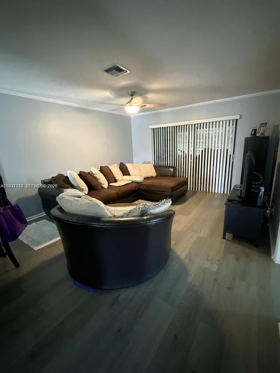 A living room features a brown sectional sofa, a dark armchair, and light wood flooring — 6720 Moonlit Dr, Delray Beach FL 33446, DELRAY BEACH, FL