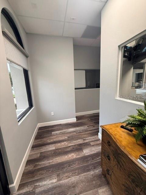 A hallway with wood-look flooring leads to an office space with a window and interior glass — 1061 S SUN DRIVE UNIT 1065, LAKE MARY, FL