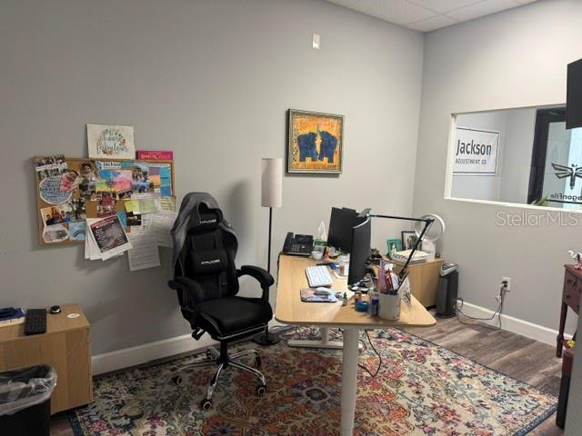 An office space features a desk, a gaming chair, a bulletin board, and a patterned rug — 1061 S SUN DRIVE UNIT 1065, LAKE MARY, FL