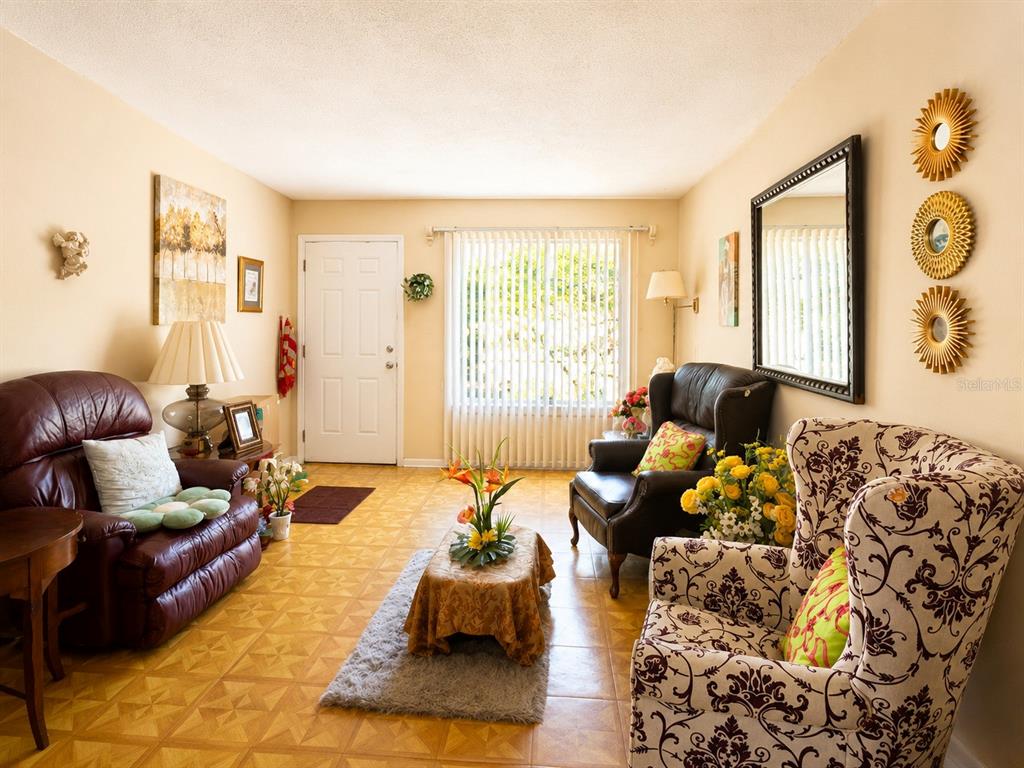 A living room features tile flooring, a leather recliner, patterned armchairs, and a large mirror — 263 ROSS ROAD, TALLAHASSEE, FL