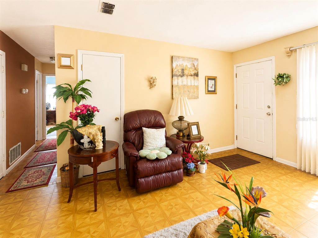 A living room features a leather recliner, a side table with flowers, and tile flooring — 263 ROSS ROAD, TALLAHASSEE, FL