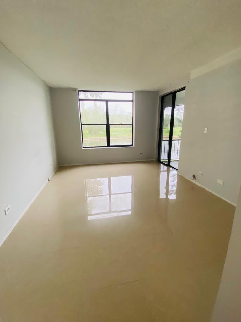 An empty room with light-colored tile flooring, a large window, and a glass balcony door — 3760 Inverrary Drive # 2h, Lauderhill FL 33319, LAUDERHILL, FL