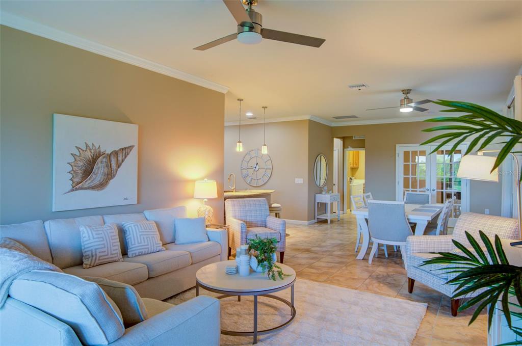 A living room with light-colored furniture, tile flooring, and a dining area in the background — 12232 MARSH POINTE ROAD, SARASOTA, FL