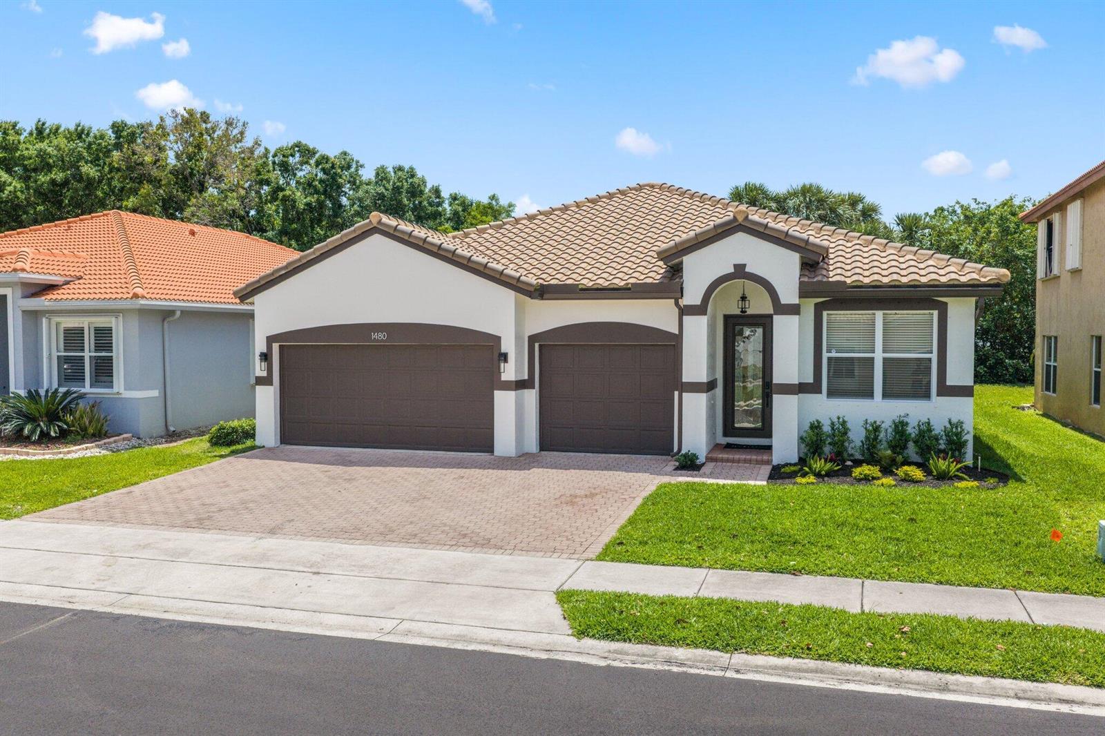 A single-story house with a tile roof, two garage doors, and a paved driveway — 1480 Artimino Lane, Boynton Beach FL 33436, BOYNTON BEACH, FL