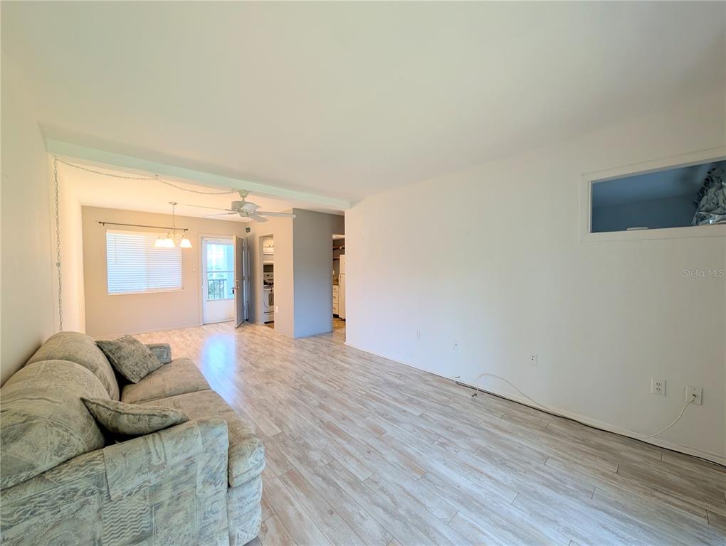 A living room with light wood-look flooring, a sofa, and a ceiling fan — 2319 CANAL DRIVE UNIT F26, BRADENTON, FL