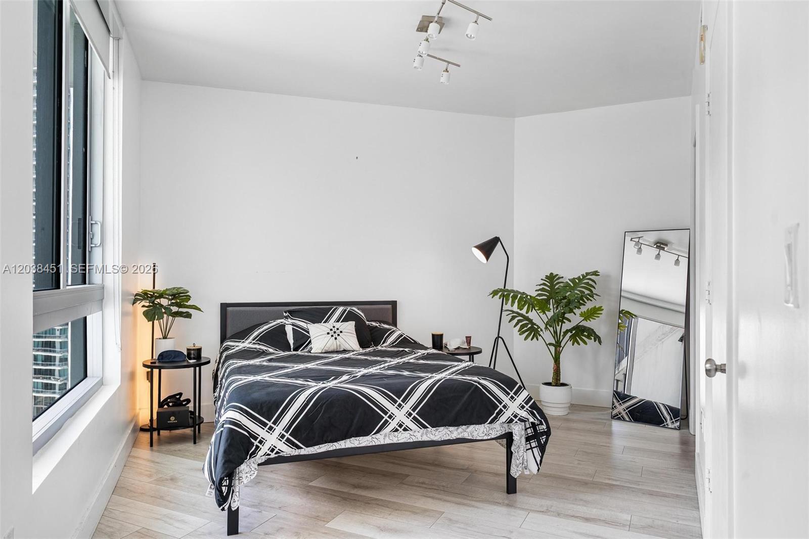 A bedroom features a bed with a black and white plaid comforter and light flooring — 350 S Miami Ave # 2108, Miami FL 33130, MIAMI, FL