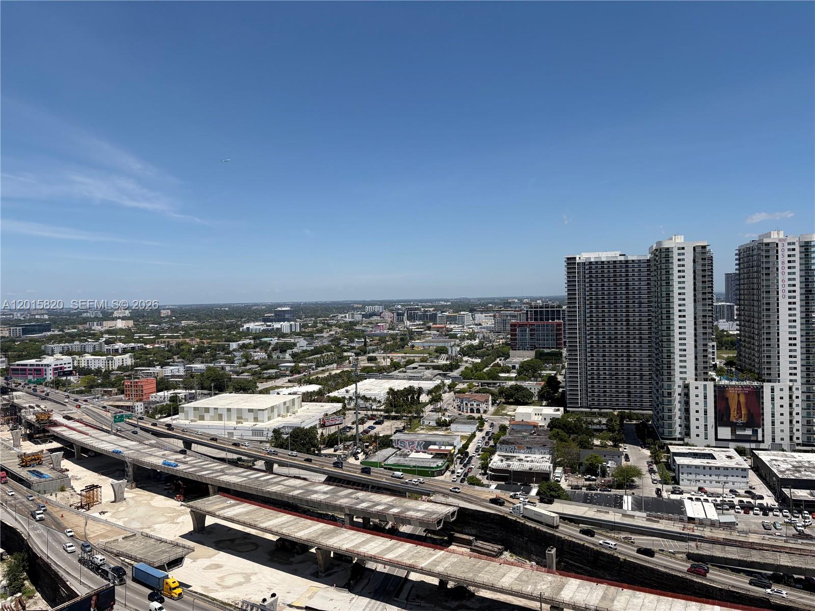 An elevated view shows a highway overpass, urban buildings, and high-rise apartments under a clear sky — 20 ne 11th st # 2805, Miami FL 33132, MIAMI, FL