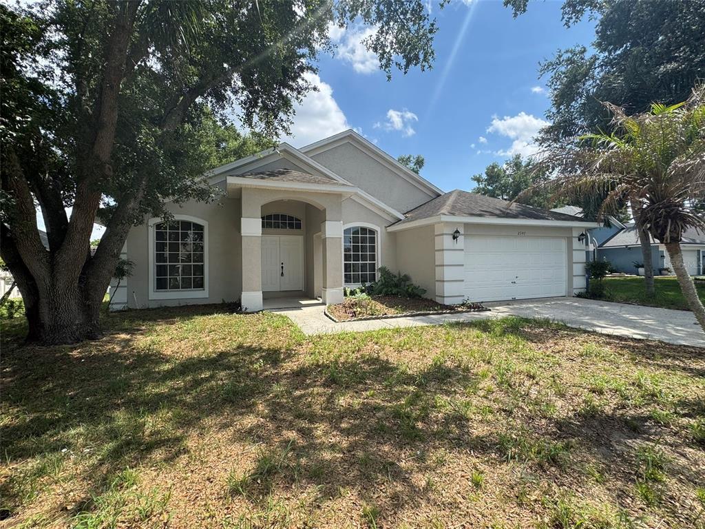 A single-story house with a white garage, arched windows, and a covered front entryway — 2347 BLAKE WAY, OCOEE, FL