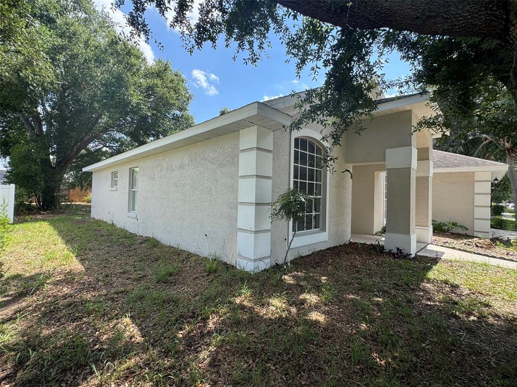 The exterior of a beige stucco house features white corner quoins and a covered entryway — 2347 BLAKE WAY, OCOEE, FL
