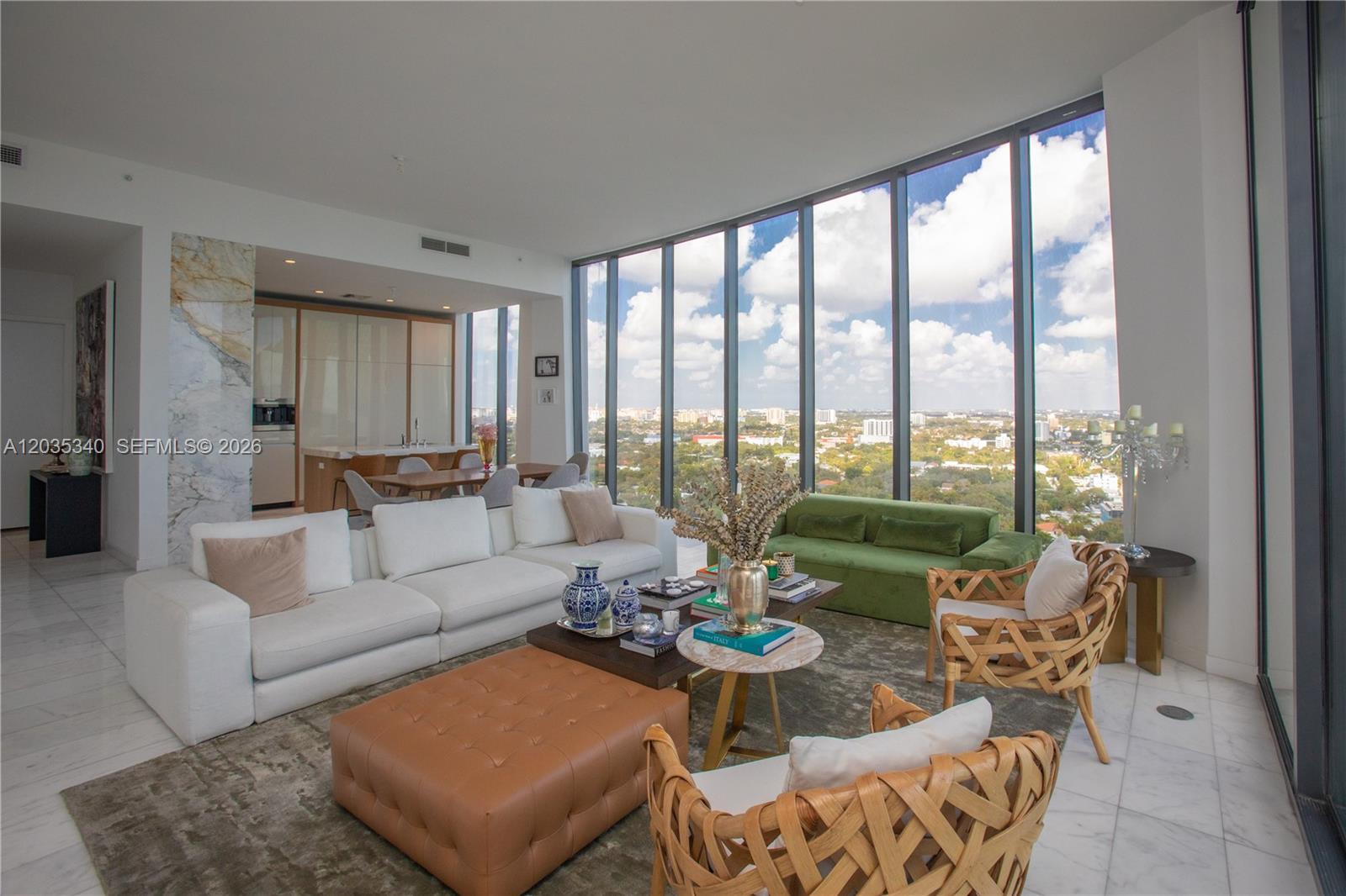A modern living room features floor-to-ceiling windows, white marble floors, and a mix of seating — 2821 S Bayshore Dr # 20D, Miami FL 33133, MIAMI, FL