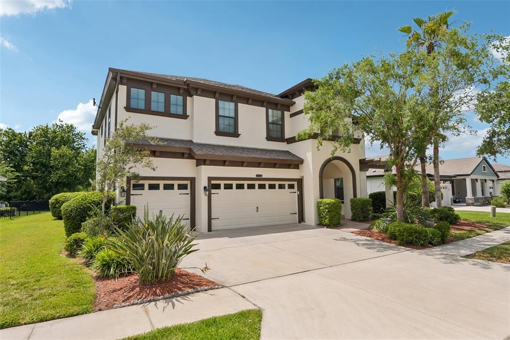 A two-story house with a three-car garage, stucco exterior, and a concrete driveway — 8355 SWISS CHARD CIRCLE, LAND O LAKES, FL