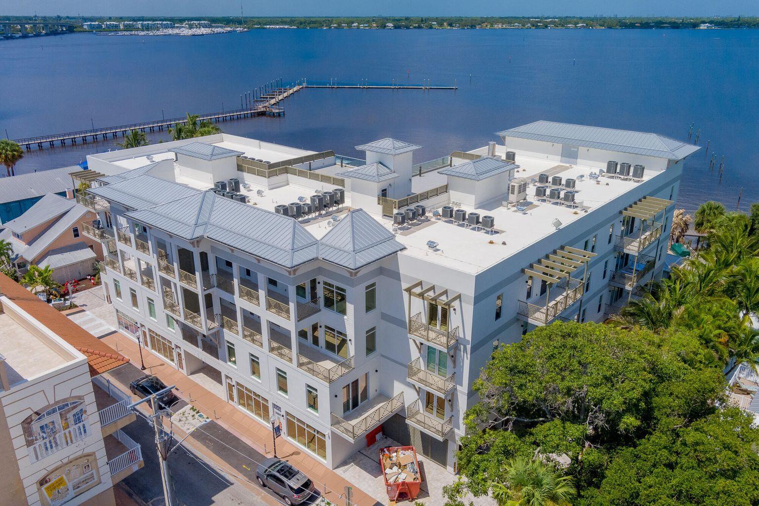 An aerial view of a multi-story building with a metal roof and balconies near water — 41 SW Seminole Street # 410, Stuart FL 34994, STUART, FL