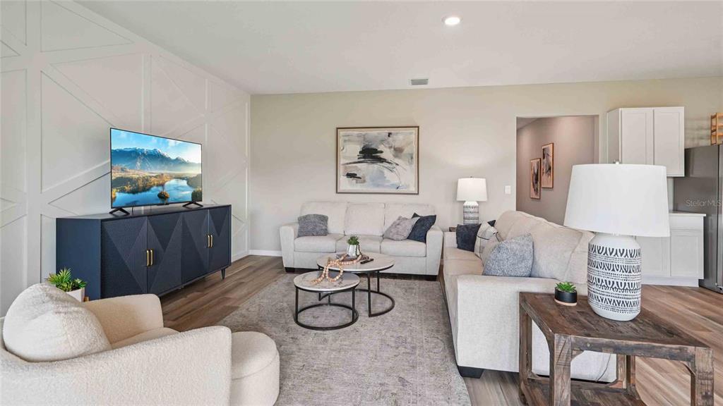 A living room features a white accent wall, a dark blue media console, and sofas — 17972 NW 170TH PLACE, ALACHUA, FL