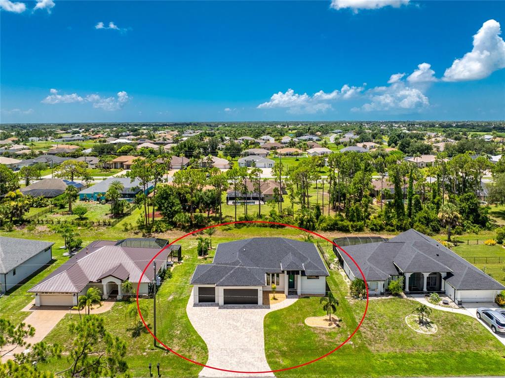 An aerial view shows a single-story house with a dark roof and paved driveway — 253 LONG MEADOW LANE, ROTONDA WEST, FL