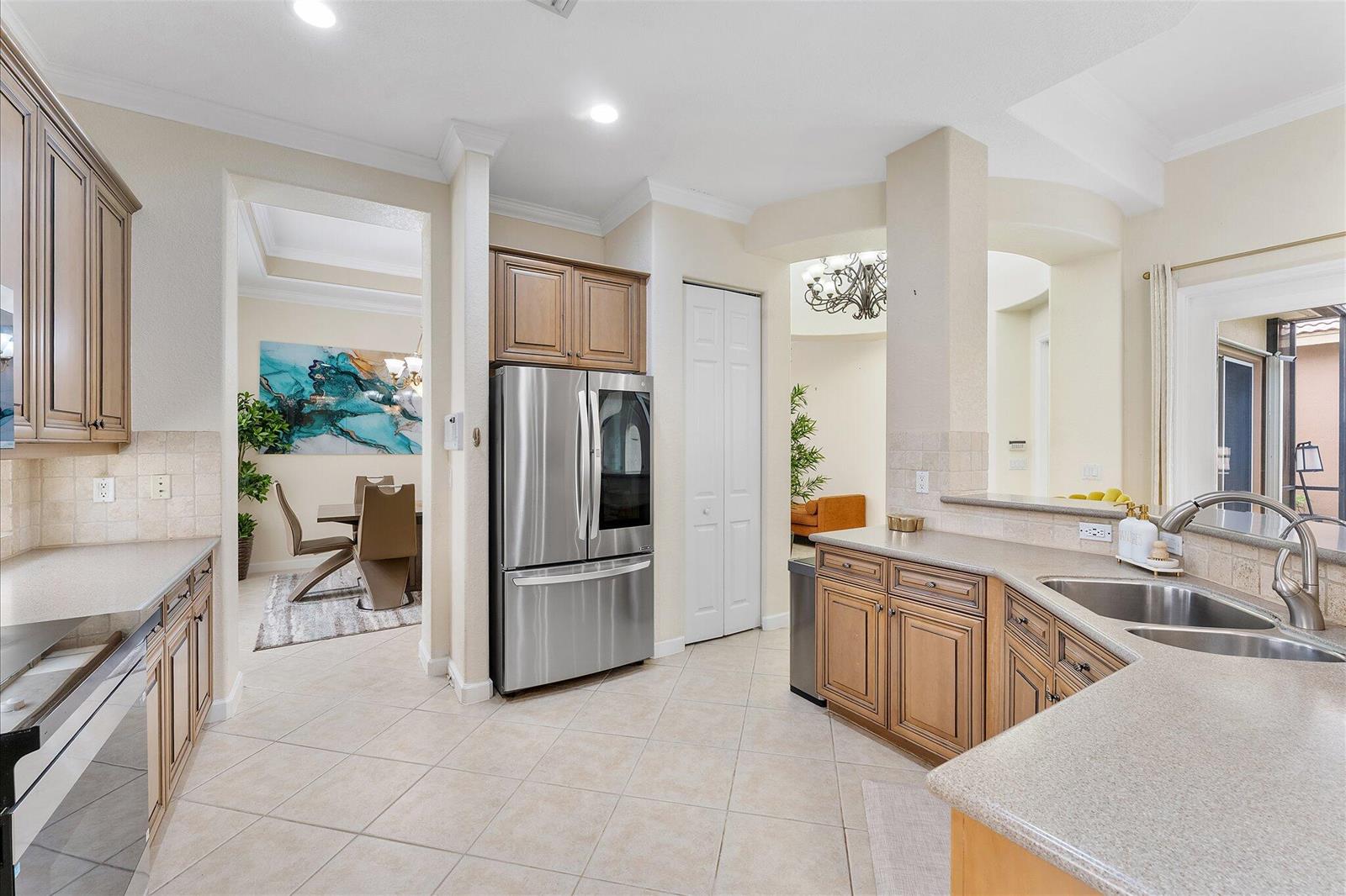 A living room with light tile floors, a ceiling fan, and a television setup — 11645 NW 71st Place, Parkland FL 33076, PARKLAND, FL